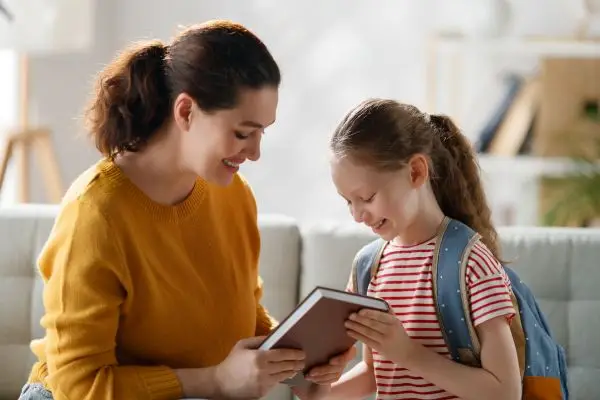 Mutter und Kind sitzen gemeinsam auf dem Sofa und lesen