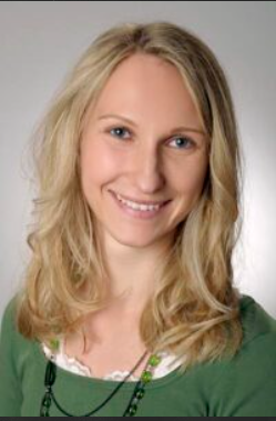 Porträt einer lächelnden blonden Frau vor grünem Hintergrund