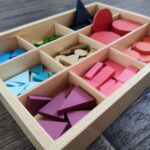 Holzkasten mit bunten geometrischen Formen als Wortartensymbole